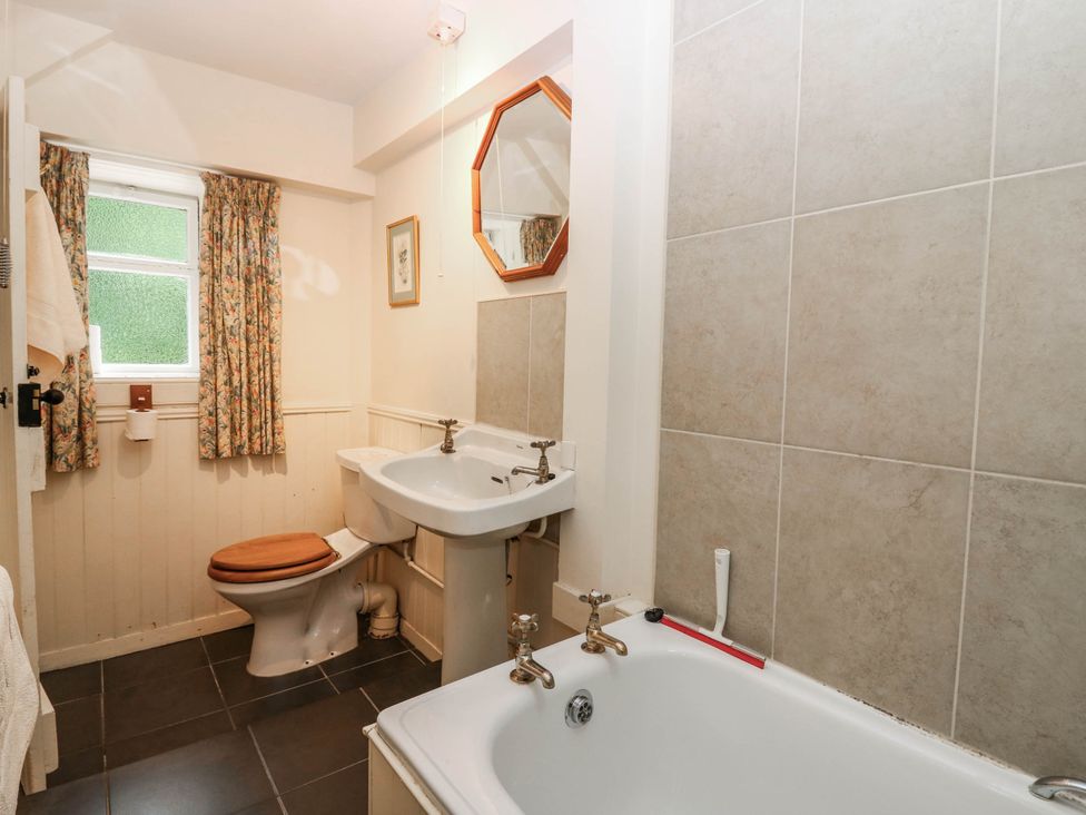 A bathroom with a toilet, wash basin, and bathtub at Gardener’s cottage in Stanley