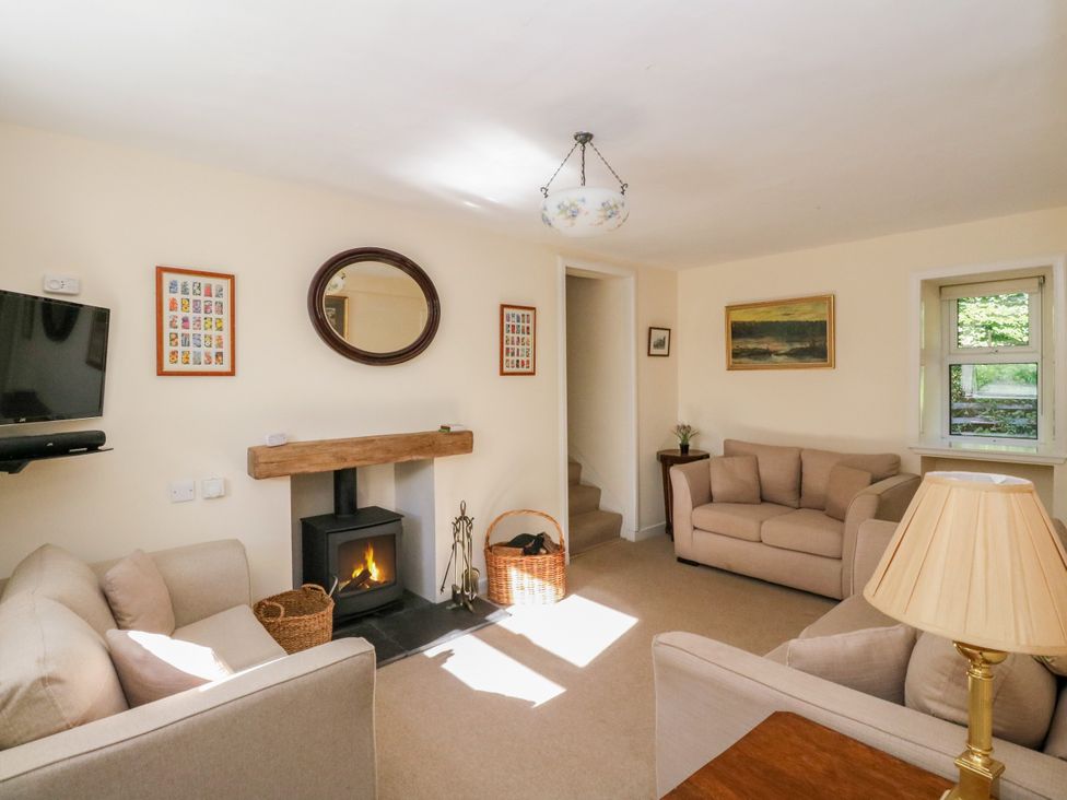 A living room with a television and fireplace at Gardener’s cottage in Stanley