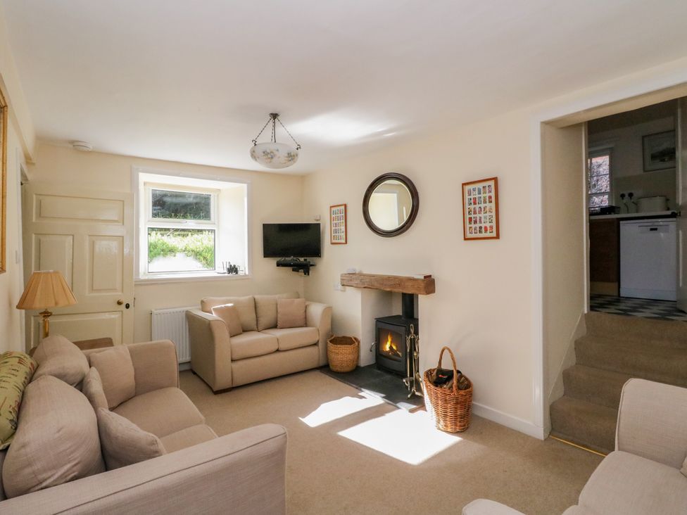 A living room with a sofa and fireplace at Gardener’s cottage in Stanley