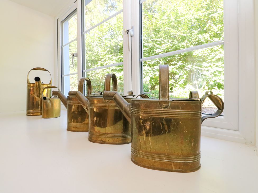 A row of watering cans on a windowsill at Gardener’s cottage in Stanley