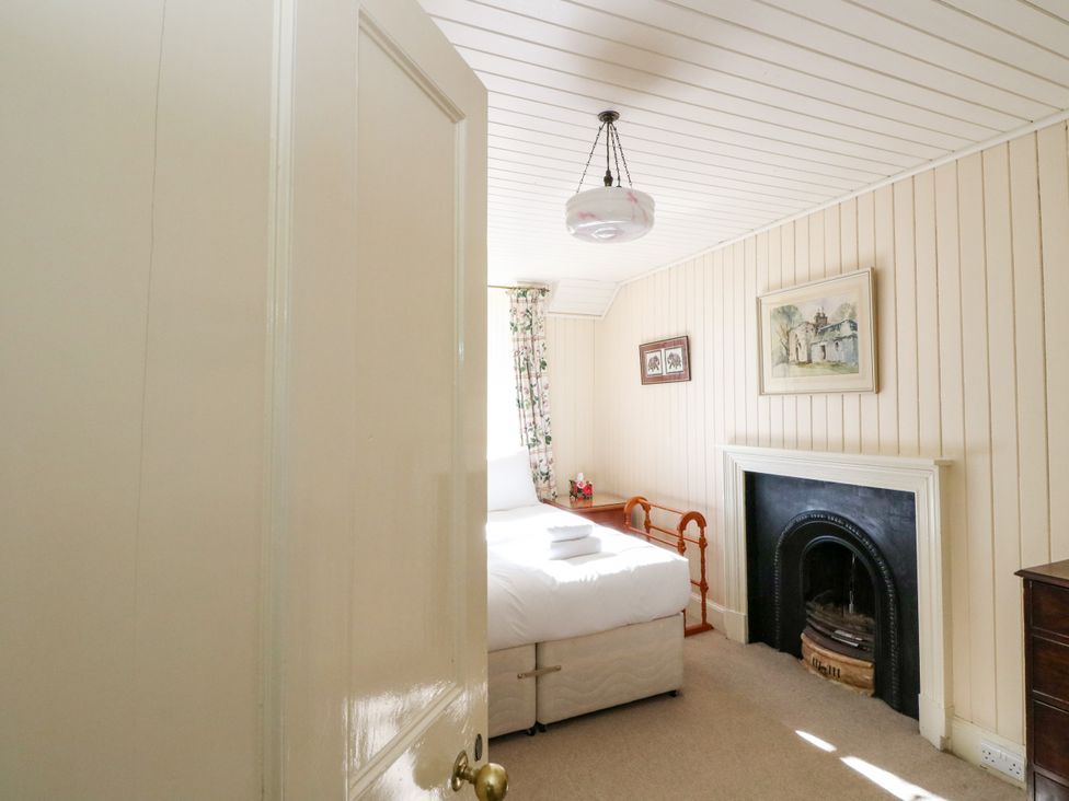 A bedroom with a bed and fireplace at Gardener’s cottage in Stanley