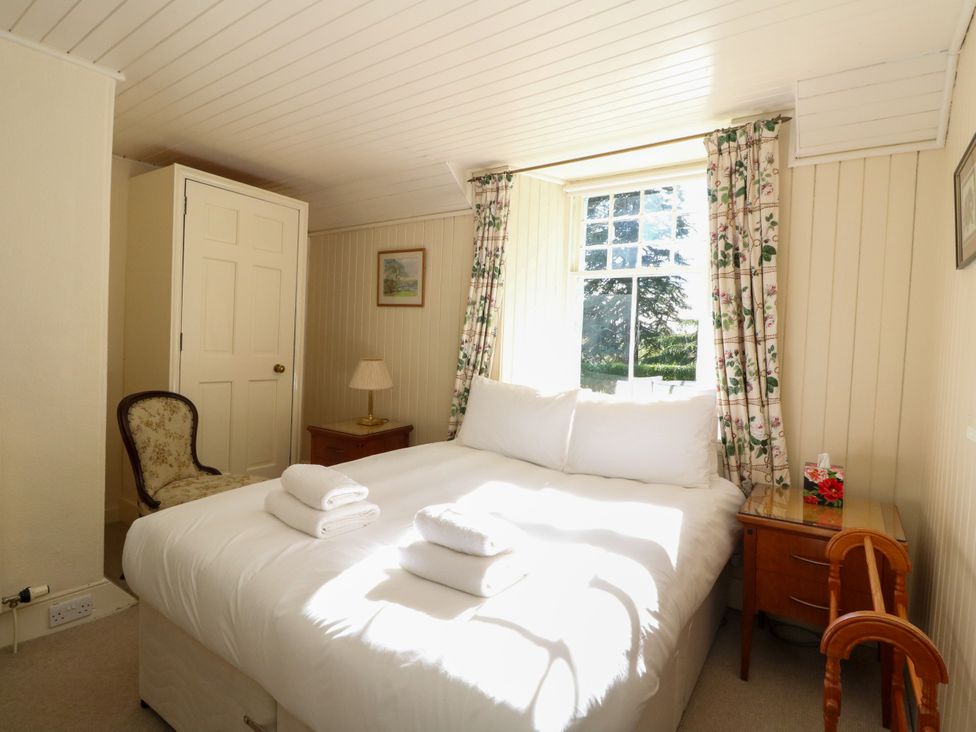 A bedroom with a bed and bedside table at Gardener’s cottage in Stanley