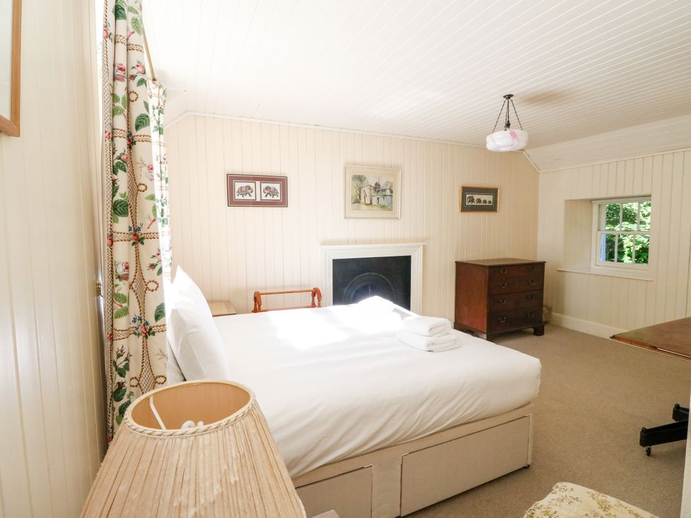 A bedroom with a bed and a fireplace at Gardener’s cottage in Stanley