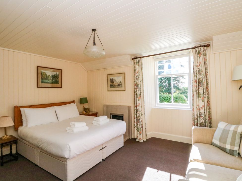 A bedroom with a bed and window at Gardener’s cottage in Stanley