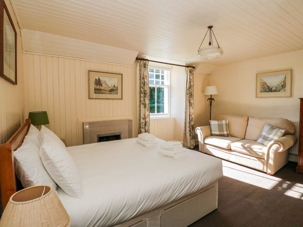 A bedroom with a bed and sofa at Gardener’s cottage in Stanley