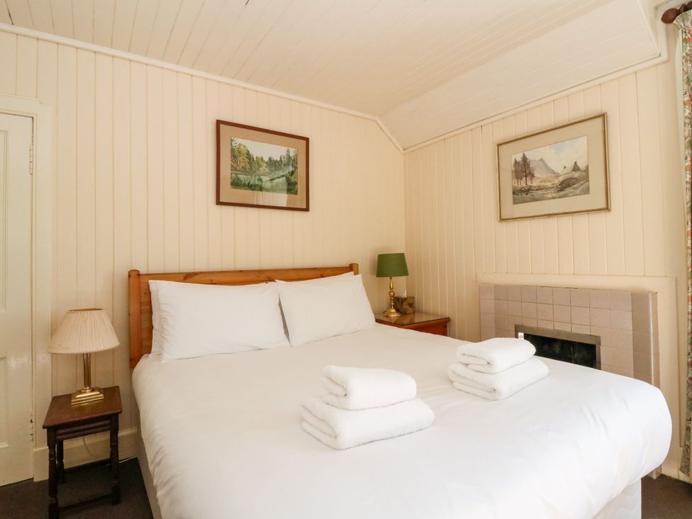 A bedroom with a bed and nightstand at Gardener’s cottage in Stanley