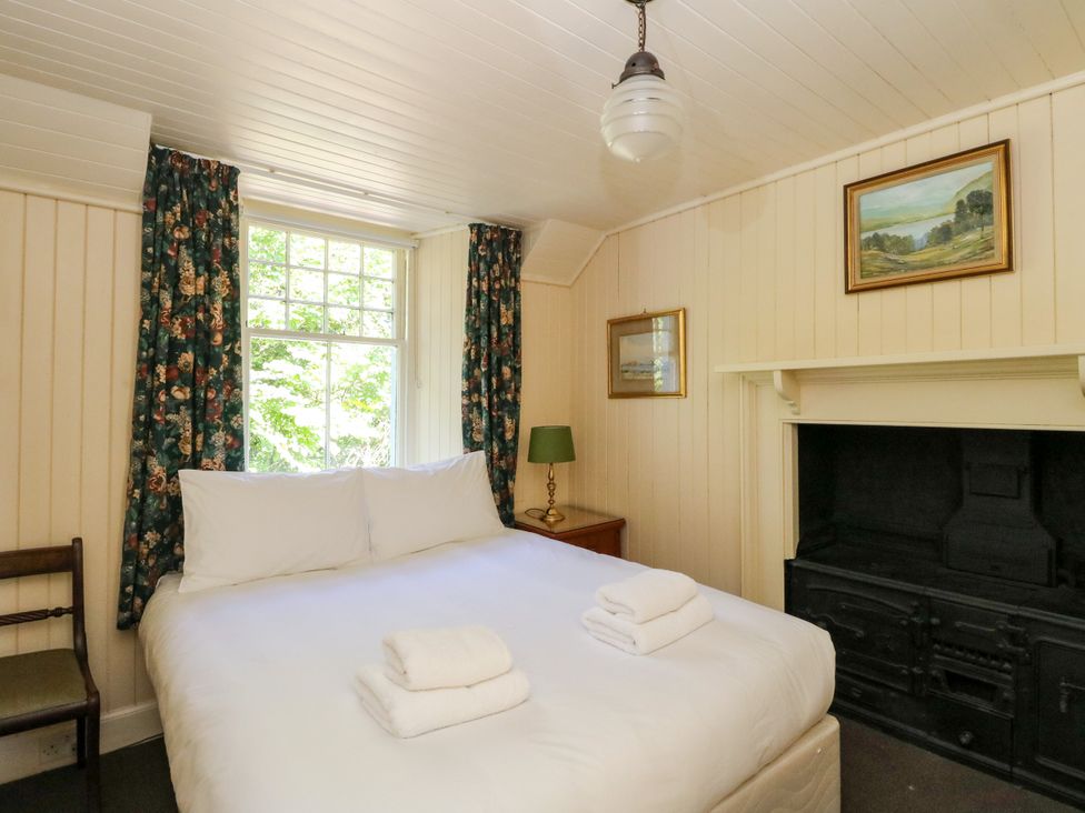 A bedroom with a bed and window at Gardener’s cottage in Stanley