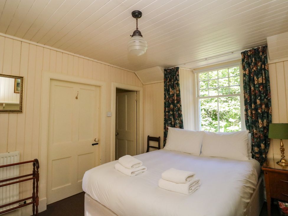 A bedroom with a bed and towels at Gardener’s cottage in Stanley