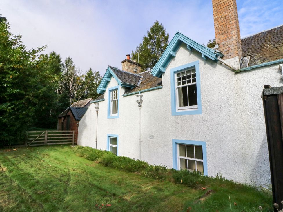 A house with grass and a fence at Gardener’s cottage in Stanley
