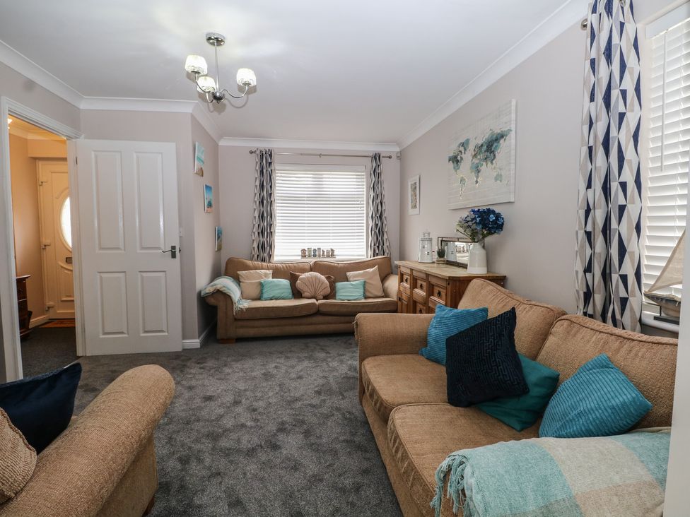 A living room with a sofa and armchair at The Willows