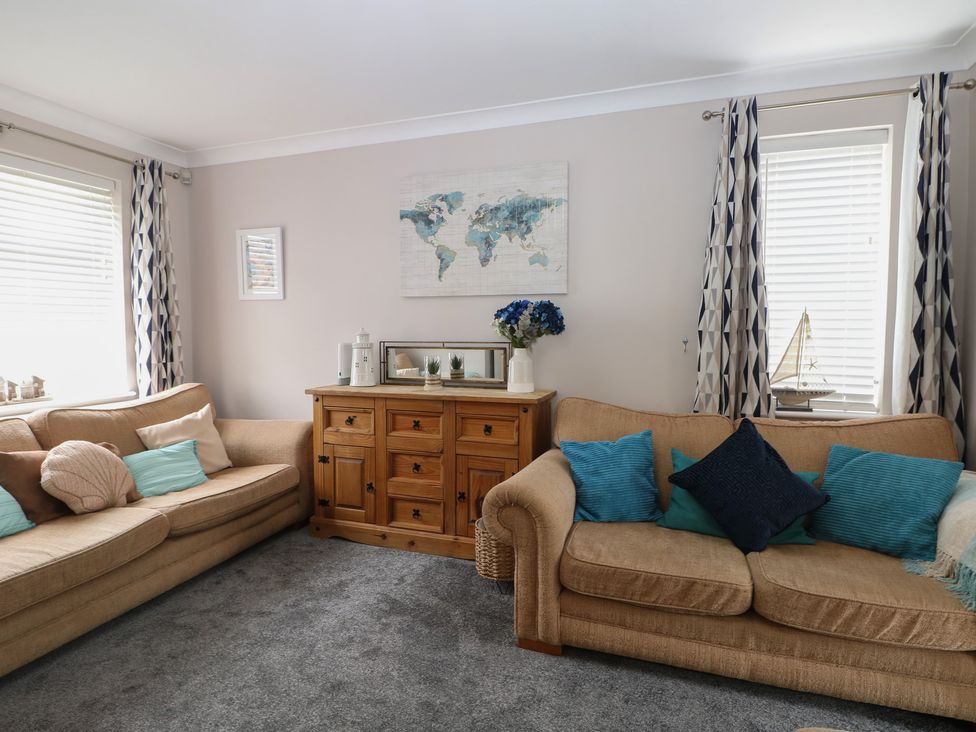 A living room with sofas and a wooden cabinet at The Willows