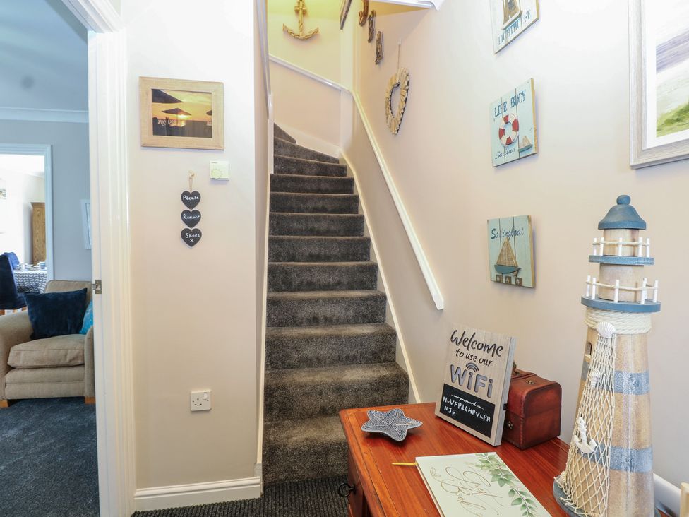 A hallway with stairs and decor items at The Willows