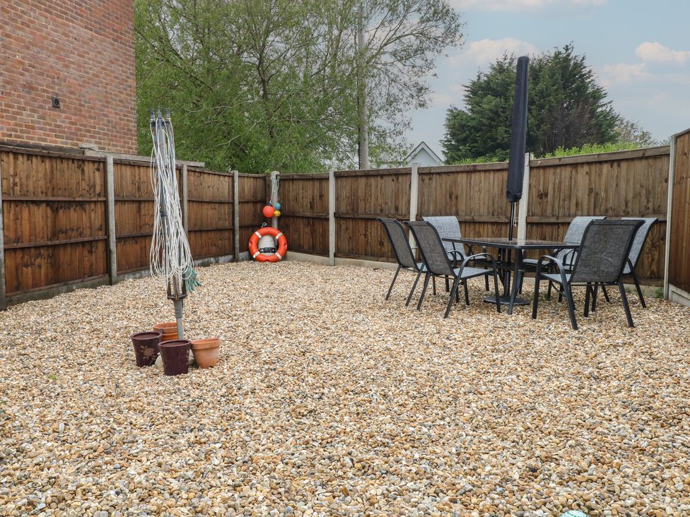 A garden with a table and chairs on gravel at The Willows in 
