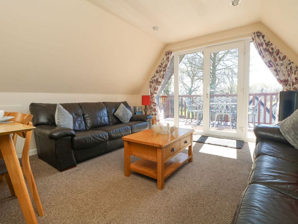 A living room with a sofa and coffee table at Honeycombe Lodge