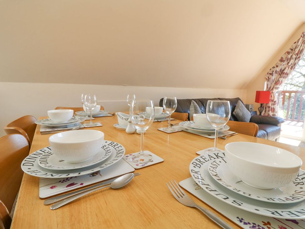 A dining table set with plates and glasses at Honeycombe Lodge