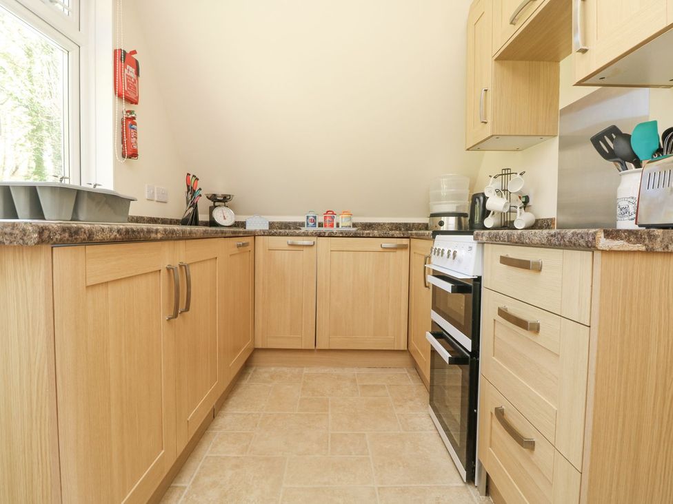 A kitchen with cabinets and appliances at Honeycombe Lodge