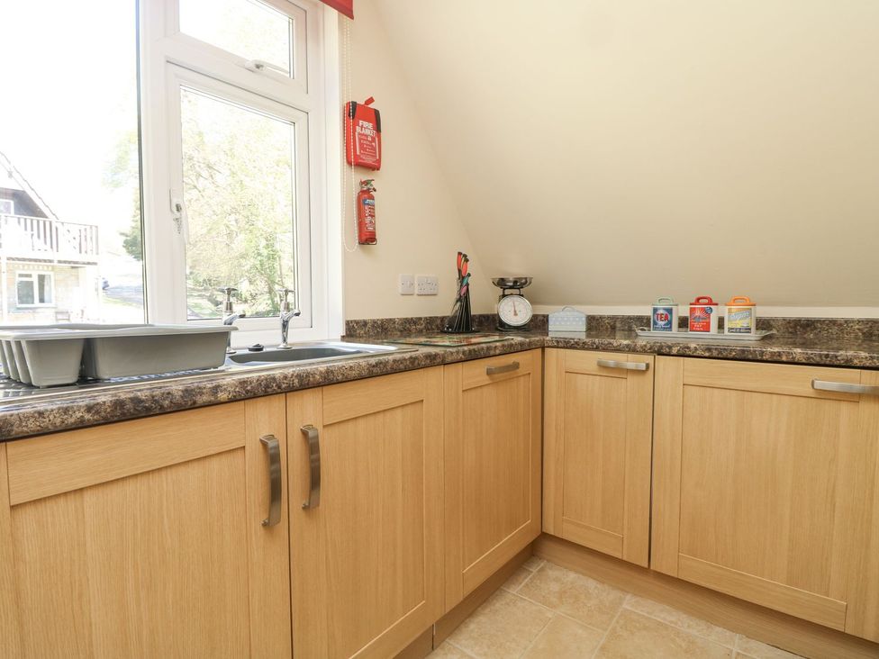 A kitchen with a sink and cabinets at Honeycombe Lodge