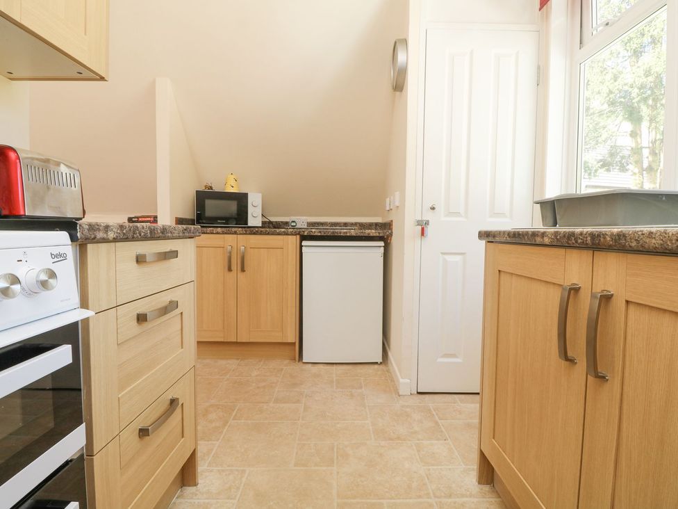 A kitchen with appliances and cabinets at Honeycombe Lodge