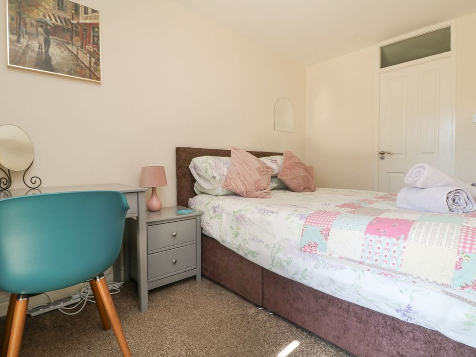 A bedroom with a bed and desk at Honeycombe Lodge