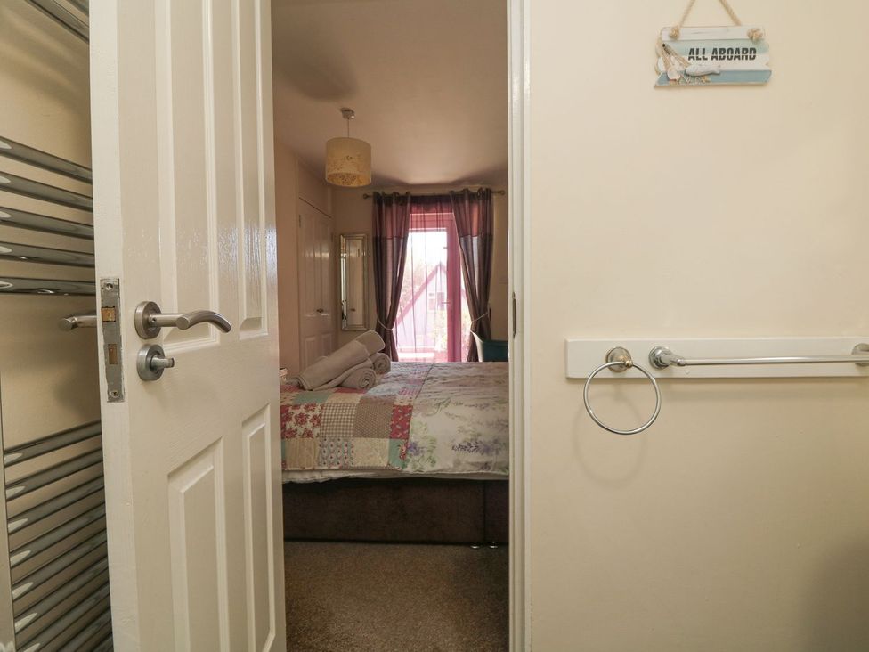 A bedroom with a bed and curtains at Honeycombe Lodge