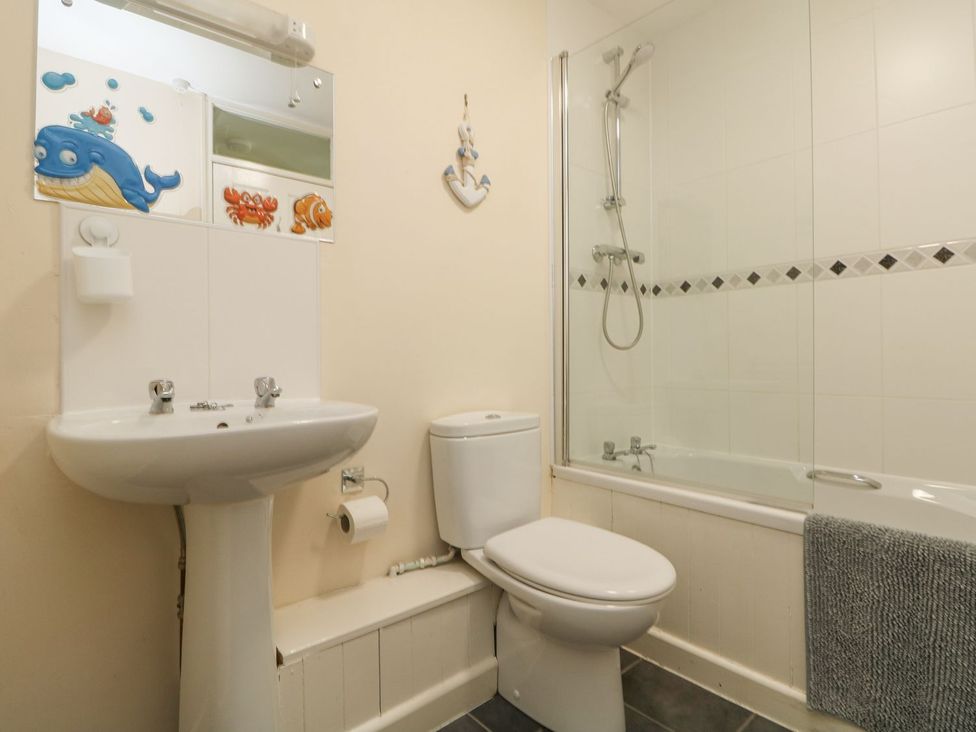 A bathroom with a sink, toilet, and bathtub at Honeycombe Lodge