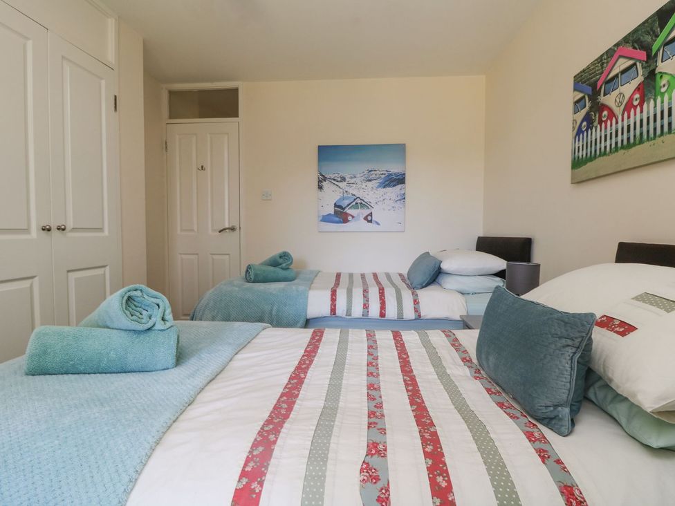 A bedroom with twin beds and towels at Honeycombe Lodge