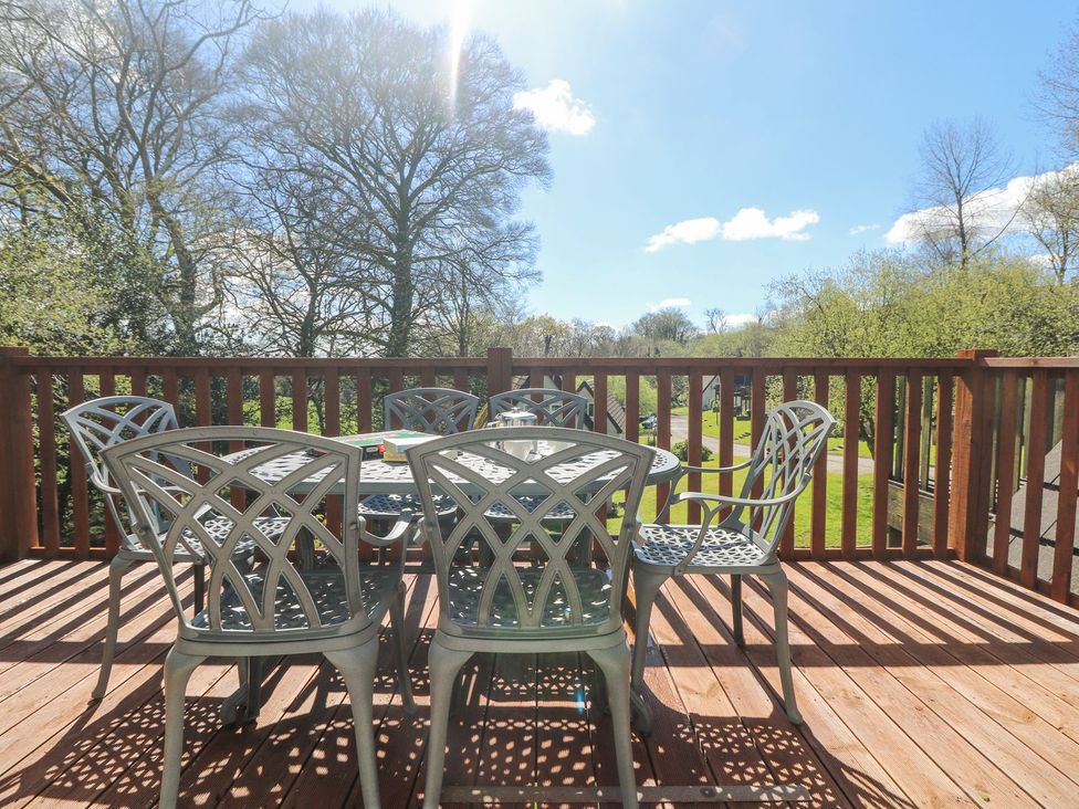A deck area with table and chairs at Honeycombe Lodge