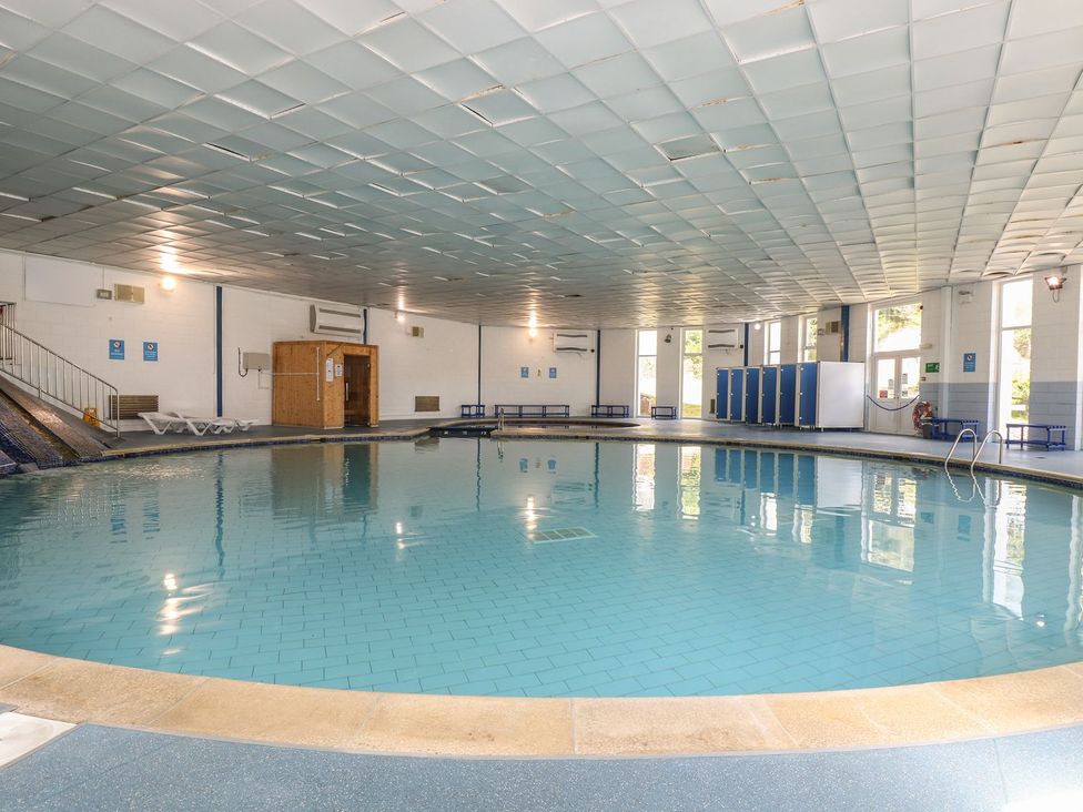 A swimming pool with changing rooms and stairs at Honeycombe Lodge