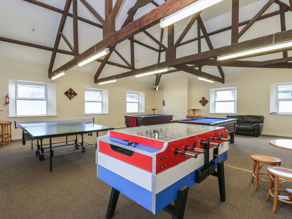 A game room with a foosball table and other game tables at Honeycombe Lodge