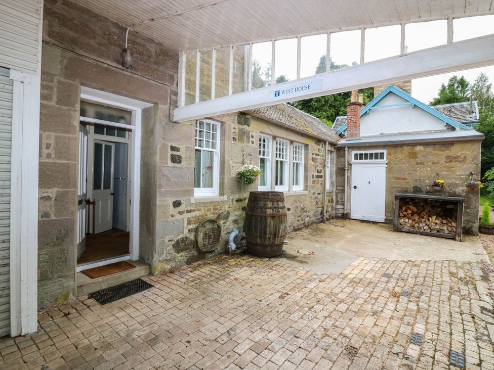 An outdoor area with a barrel and wood storage at West House in Perth