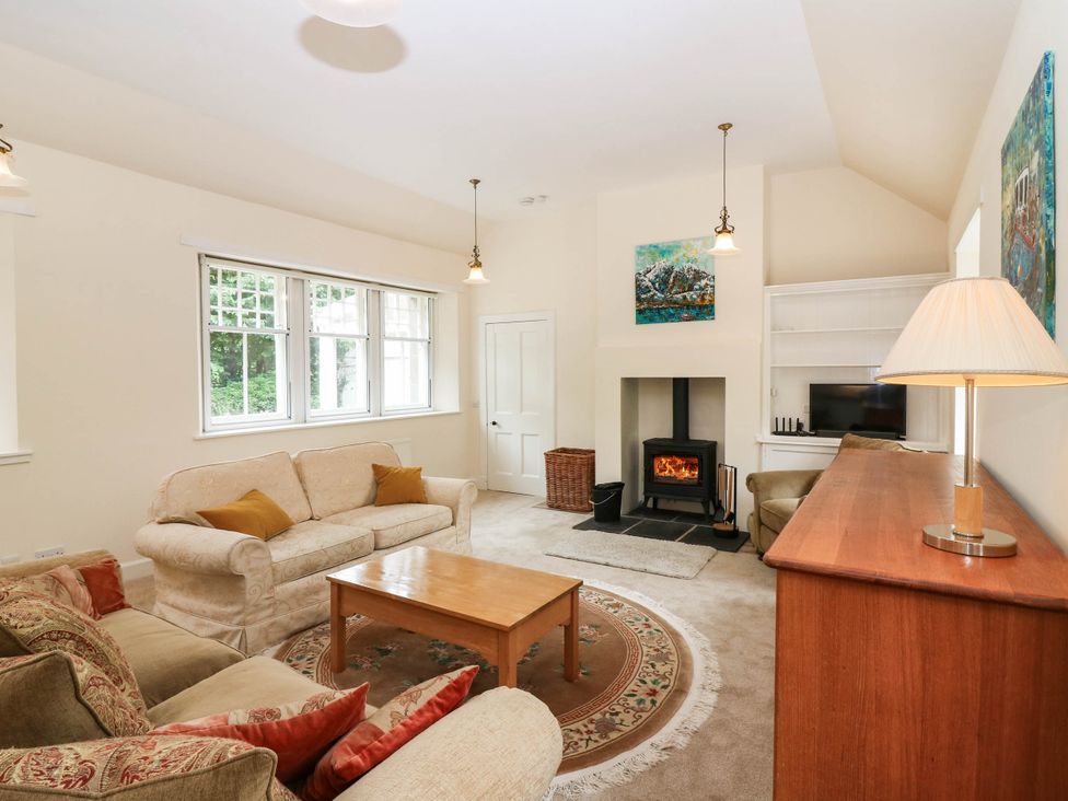 A living room with a fireplace and sofa at West House in Perth