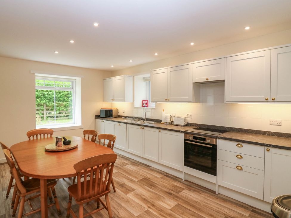 A kitchen with a dining table and chairs at West House in Perth