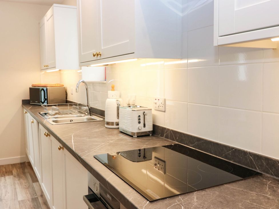 A kitchen with a sink, cooking hob and appliances at West House in Perth