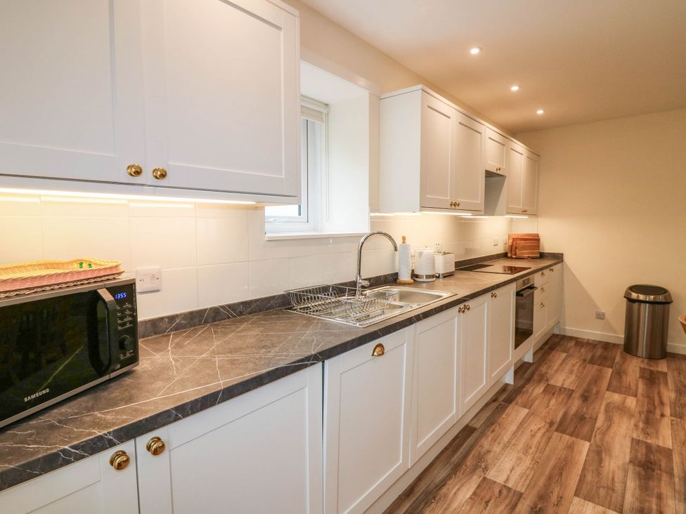A kitchen with cabinets and appliances at West House in Perth