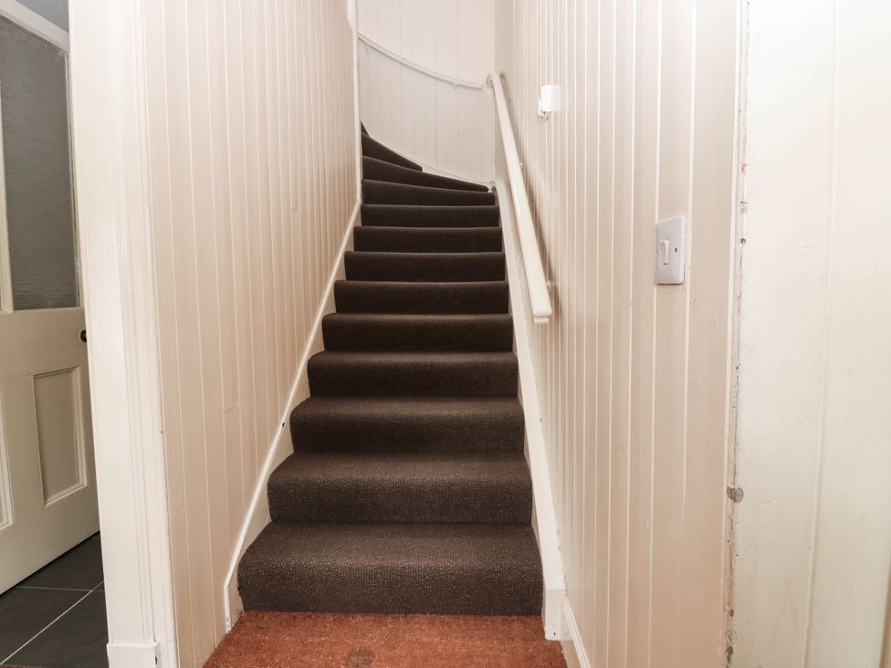 A staircase with a handrail and light switch at West House in Perth