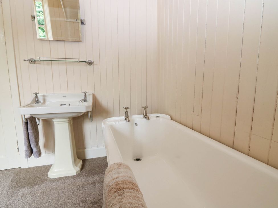 A bathroom with a bathtub and wash basin at West House in Perth