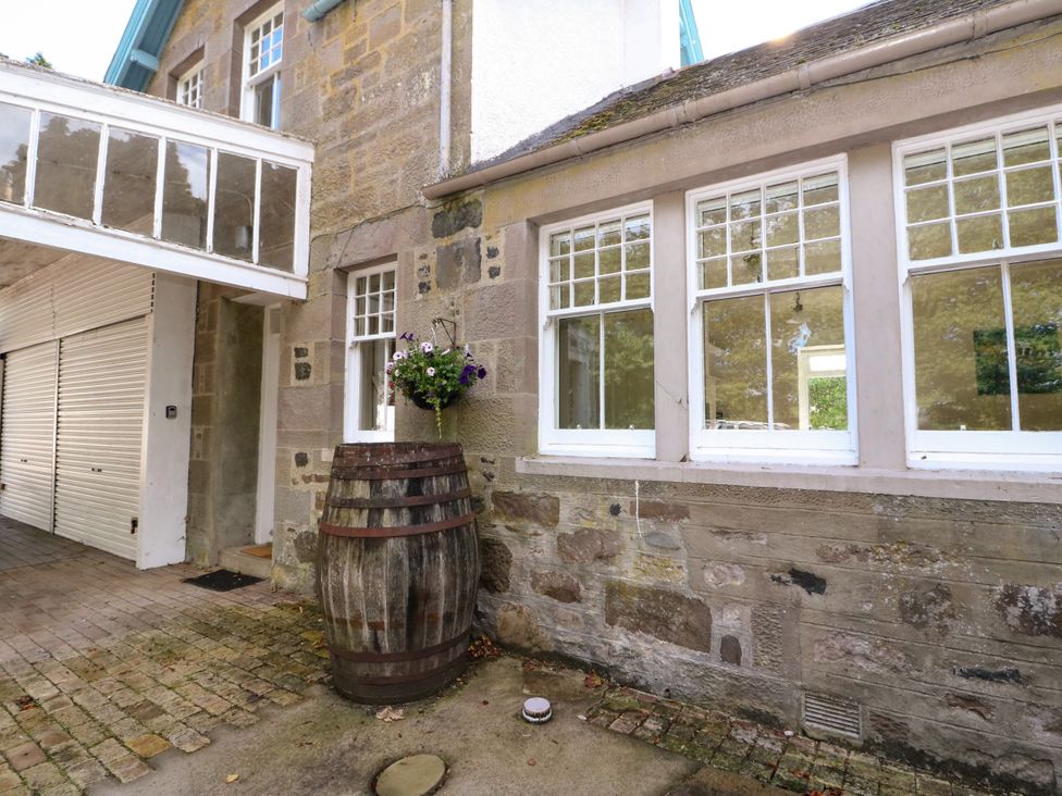 An outdoor area with a barrel and flowers at West House in Stanley