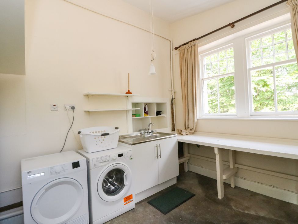 A laundry room with a washing machine and sink at West House in Stanley