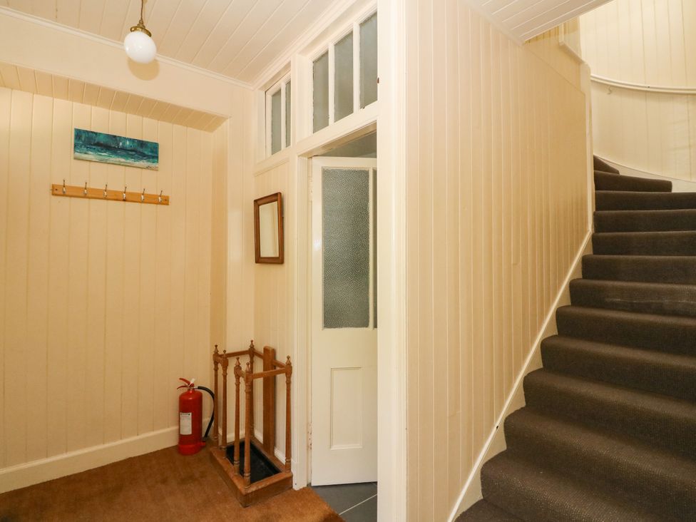 A hallway with a staircase and coat hooks at West House in Stanley