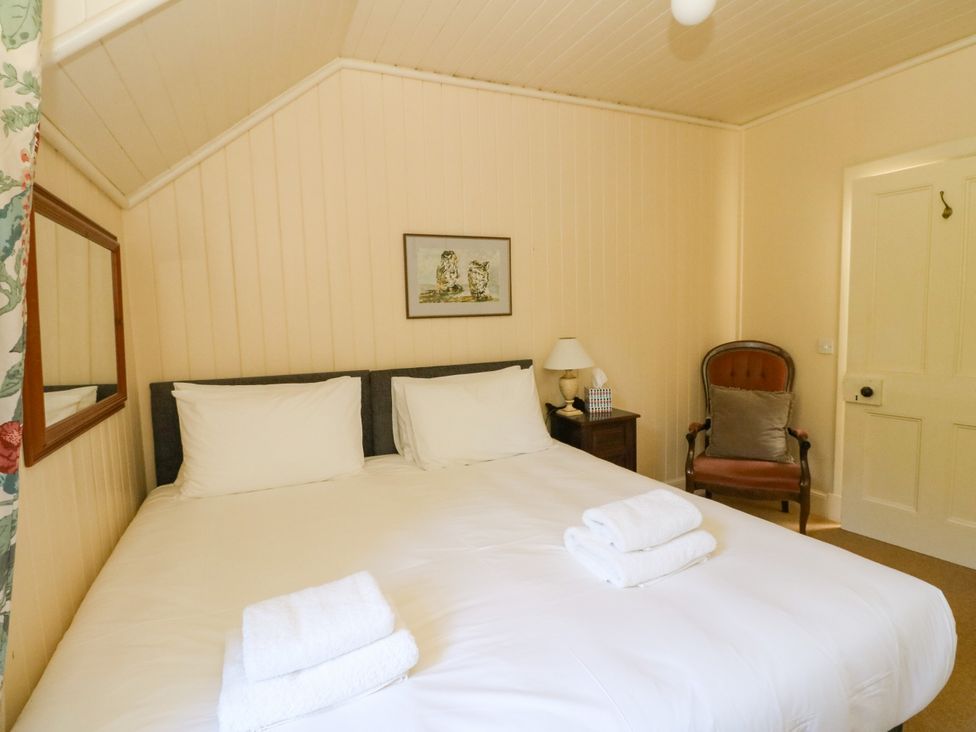 A bedroom with a double bed and armchair at West House in Stanley