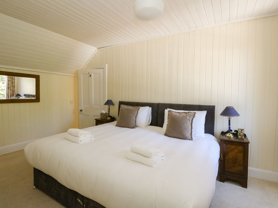 A bedroom with a bed and a mirror at West House in Stanley