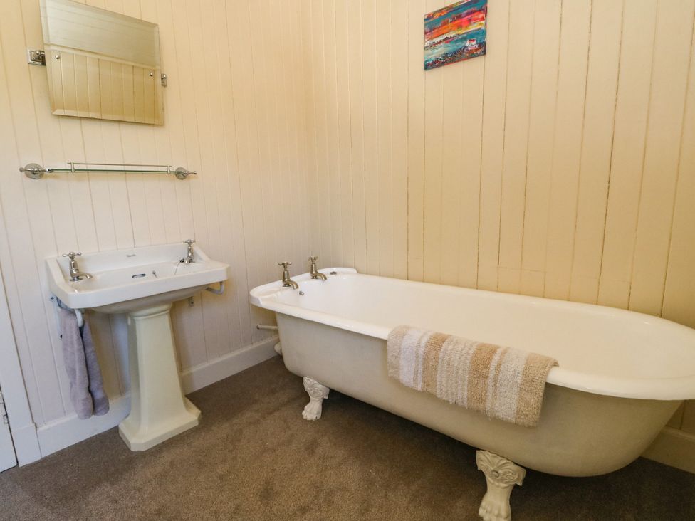 A bathroom with a bathtub and sink at West House in Stanley