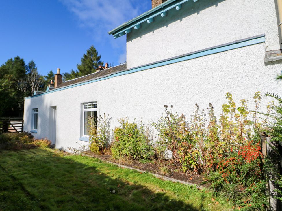 A view of the side of a house with bushes and grass at West House in Stanley