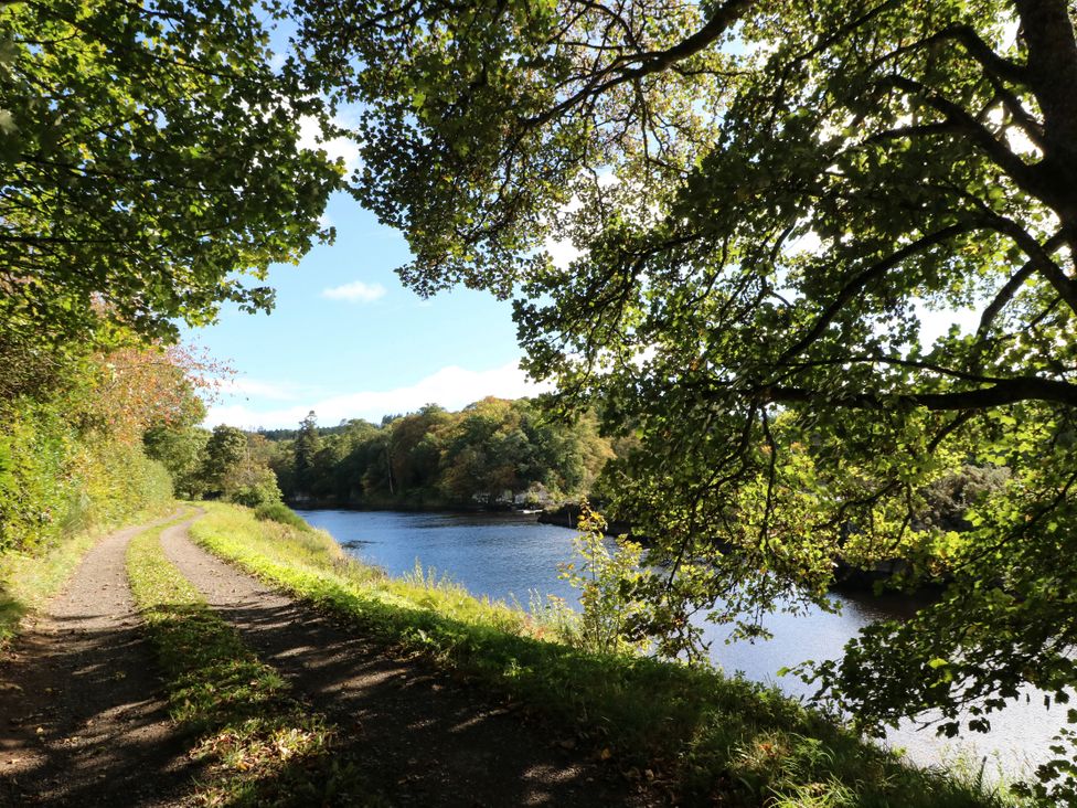 A path alongside a river with trees and greenery at West House in Stanley
