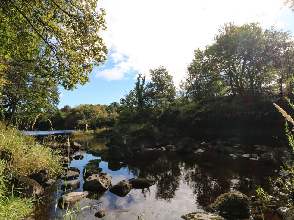 A river with rocks and trees at West House in Stanley