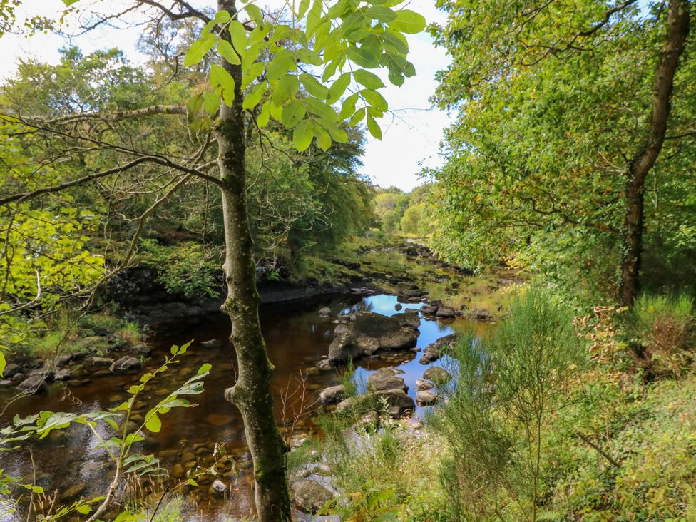 A river with rocks and trees surrounding it at West House in Stanley