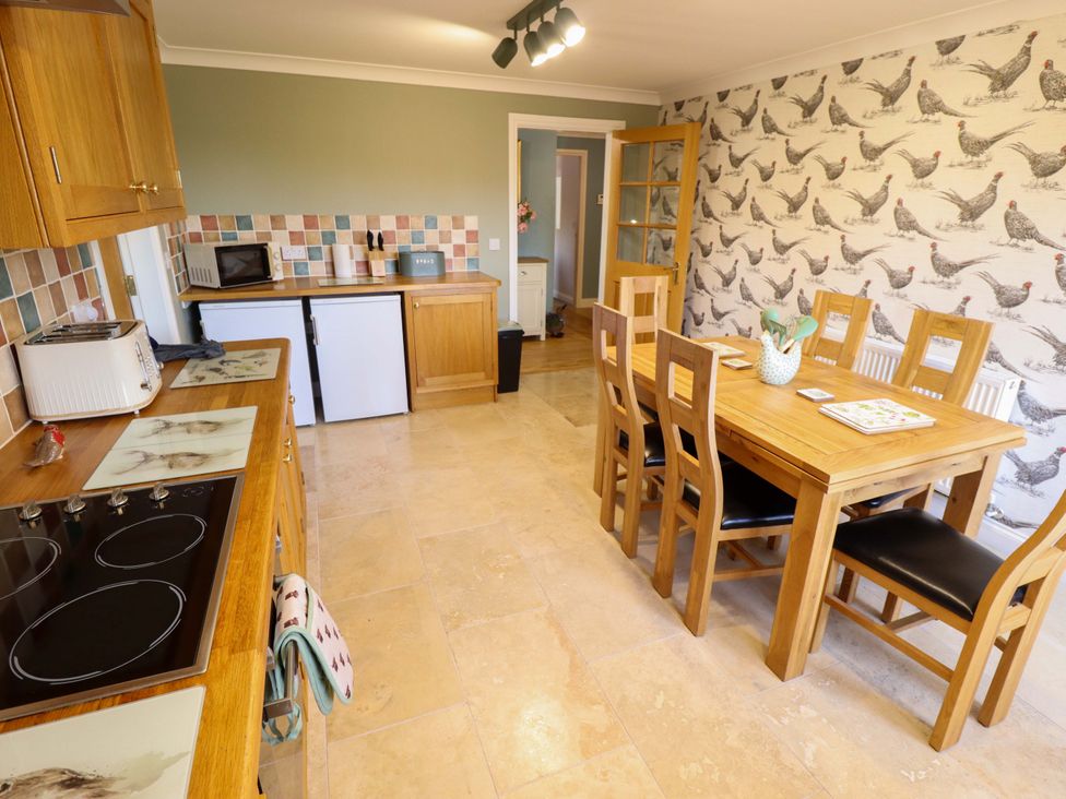 A kitchen with a dining table and appliances at Rowan Cottage in Boston