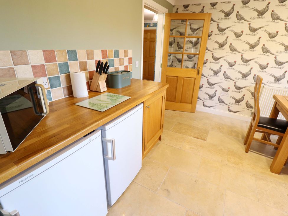 A kitchen with a wooden countertop and appliances at Rowan Cottage in Boston