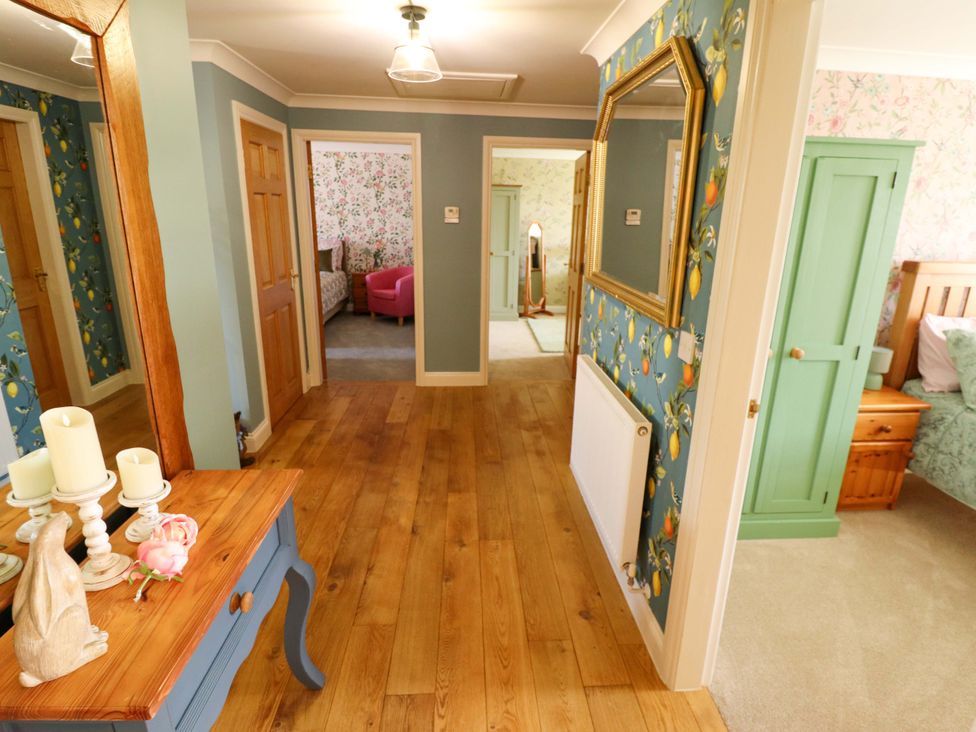 A hallway with a console table and doors at Rowan Cottage in Boston