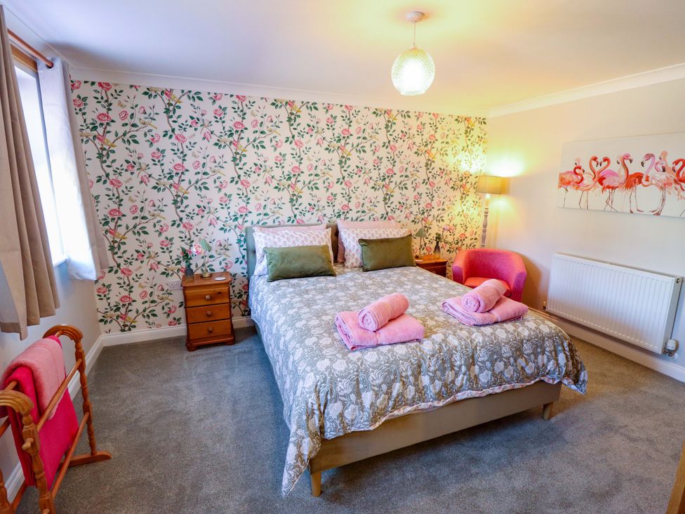 A bedroom with a bed and decorative wall at Rowan Cottage in Boston